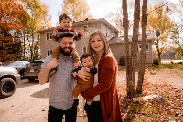 Happy family standing outside home